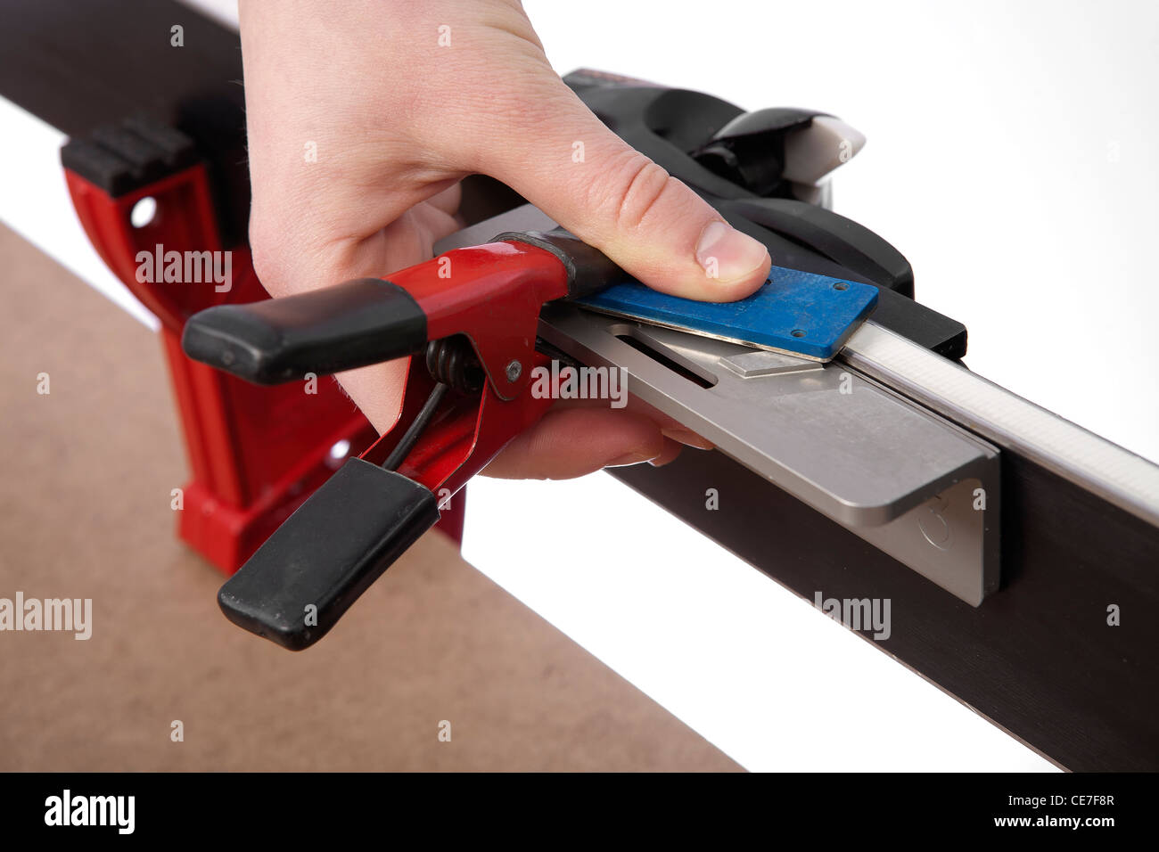 hand holding ski tuning side bevel guide and diamond stone performing