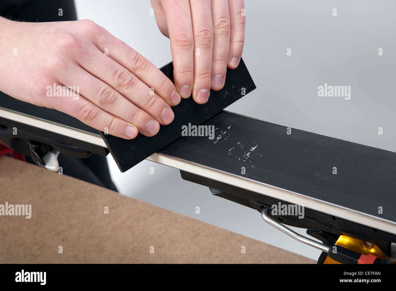 removing excess wax from race ski base with plastic scraper Stock Photo