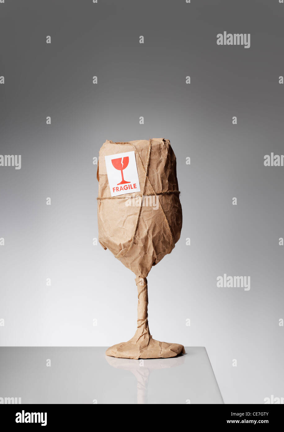An obviously fragile object wrapped in paper and with a 'fragile' sticker. Stock Photo