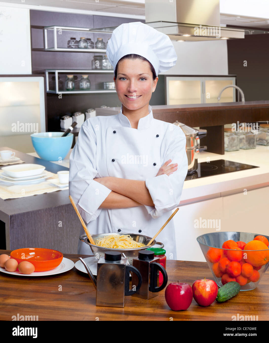 Chef woman portrait with white uniform in the kitchen Stock Photo