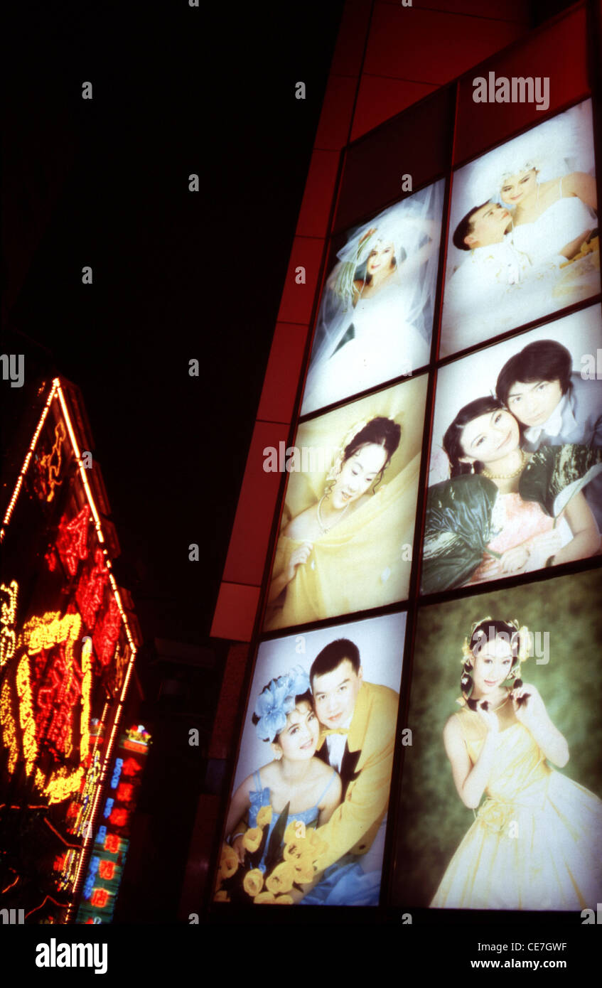 Chinese brides and grooms in an illuminated billboard in Wangfujing street in Beijing China Stock Photo