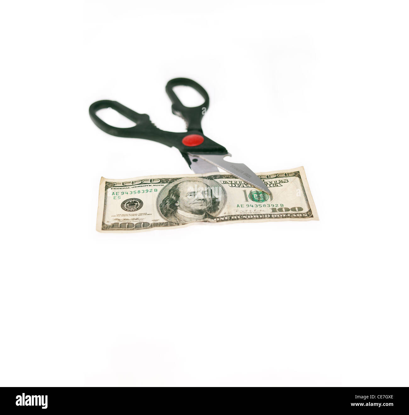 opened stainless scissors cutting us dollar bill closeup isolated on white Stock Photo