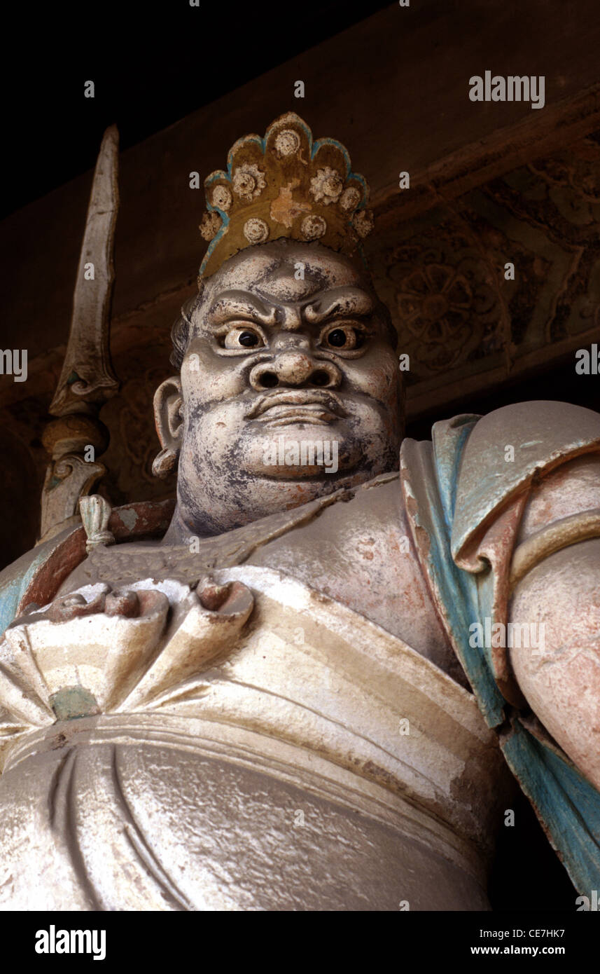 An old terracotta sculpture depicting a temple guardian in Shuanglin Si Buddhist temple date to the Ming and Qing dynasties near the city of Ping Yao officially Pingyao Ancient City in central Shanxi, China Stock Photo