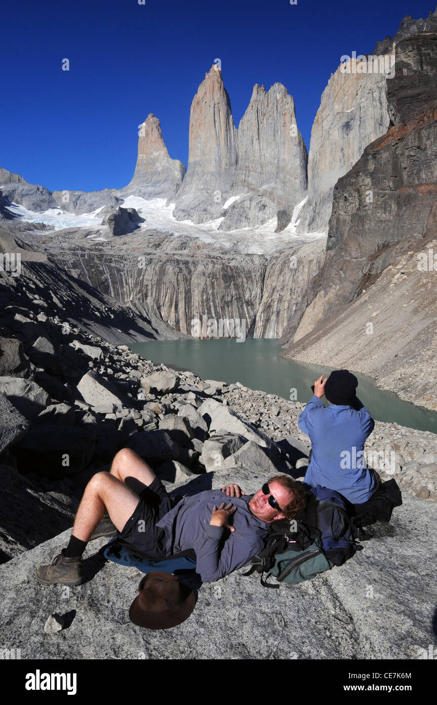 Hikers resting below the spectacular Torres del Paine, Torres del Paine National Park, Patagonia, Chile. No MR Stock Photo