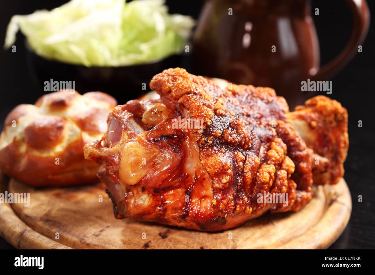 Grilled knuckle of pork with bread rolls and lettuce salad Stock Photo