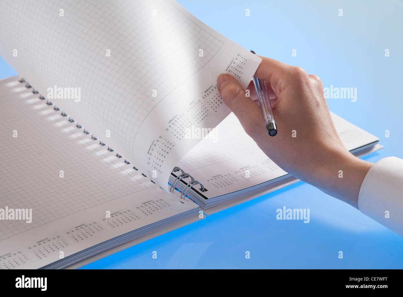 Female hand turning over a blank page Stock Photo