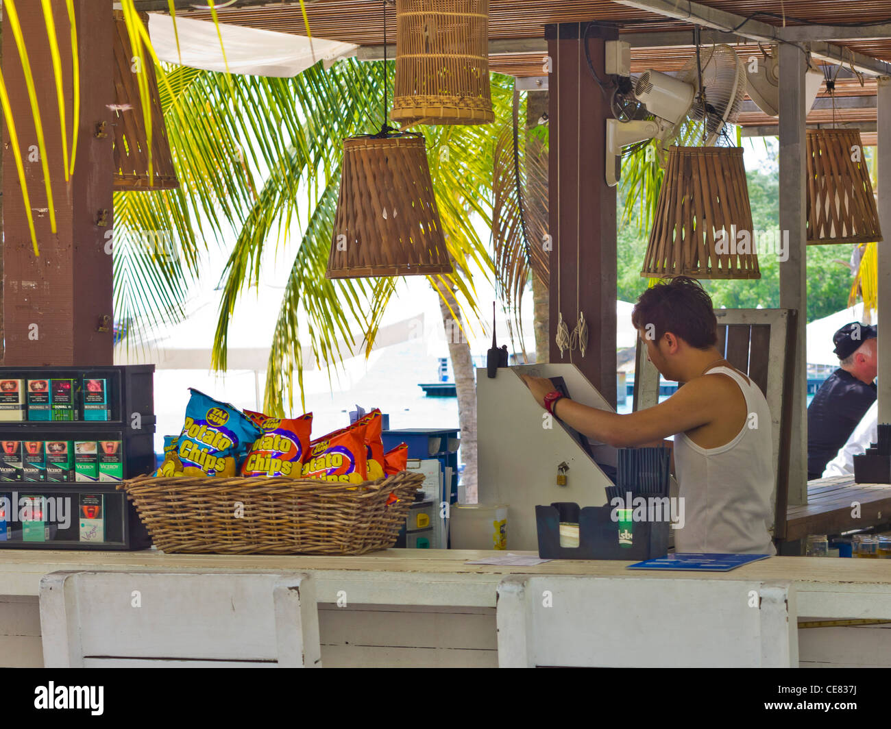 Barman operating till at rustic beachside bar at Sentosa Island