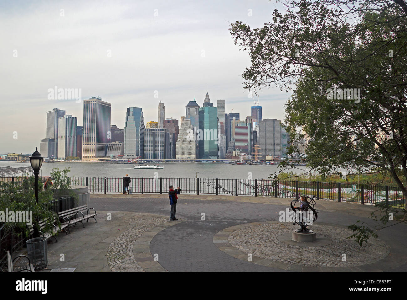 People enjoying and taking photographs on the Brooklyn Heights Promenade, overlooking the East River and Lower Manhattan Stock Photo