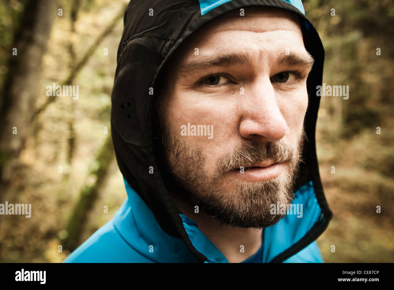 Portrait of a bearded young man wearing a hooded running jacket. Stock Photo