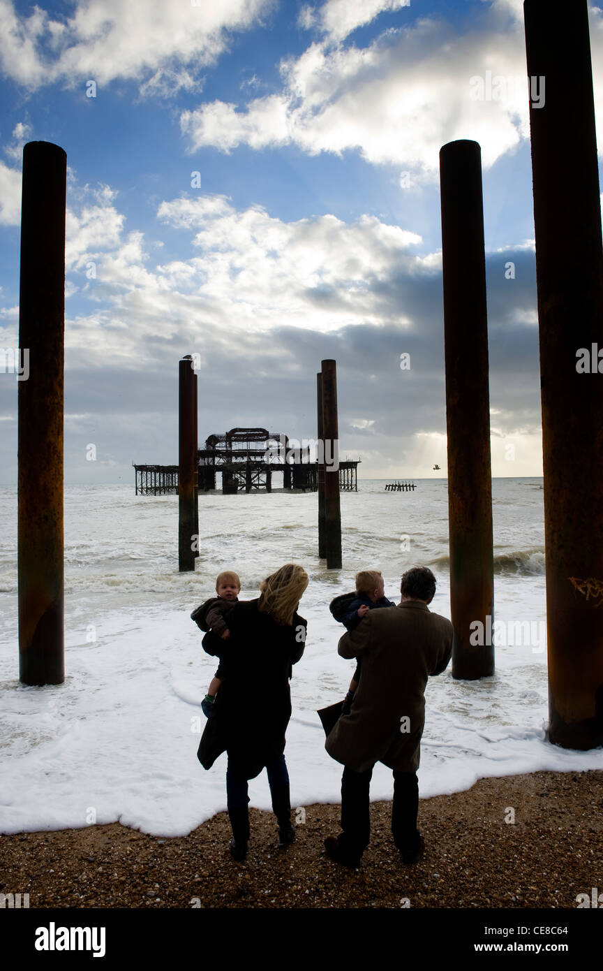 Couple with twins at the edge of the sea Old West Pier, Brighton, England Stock Photo