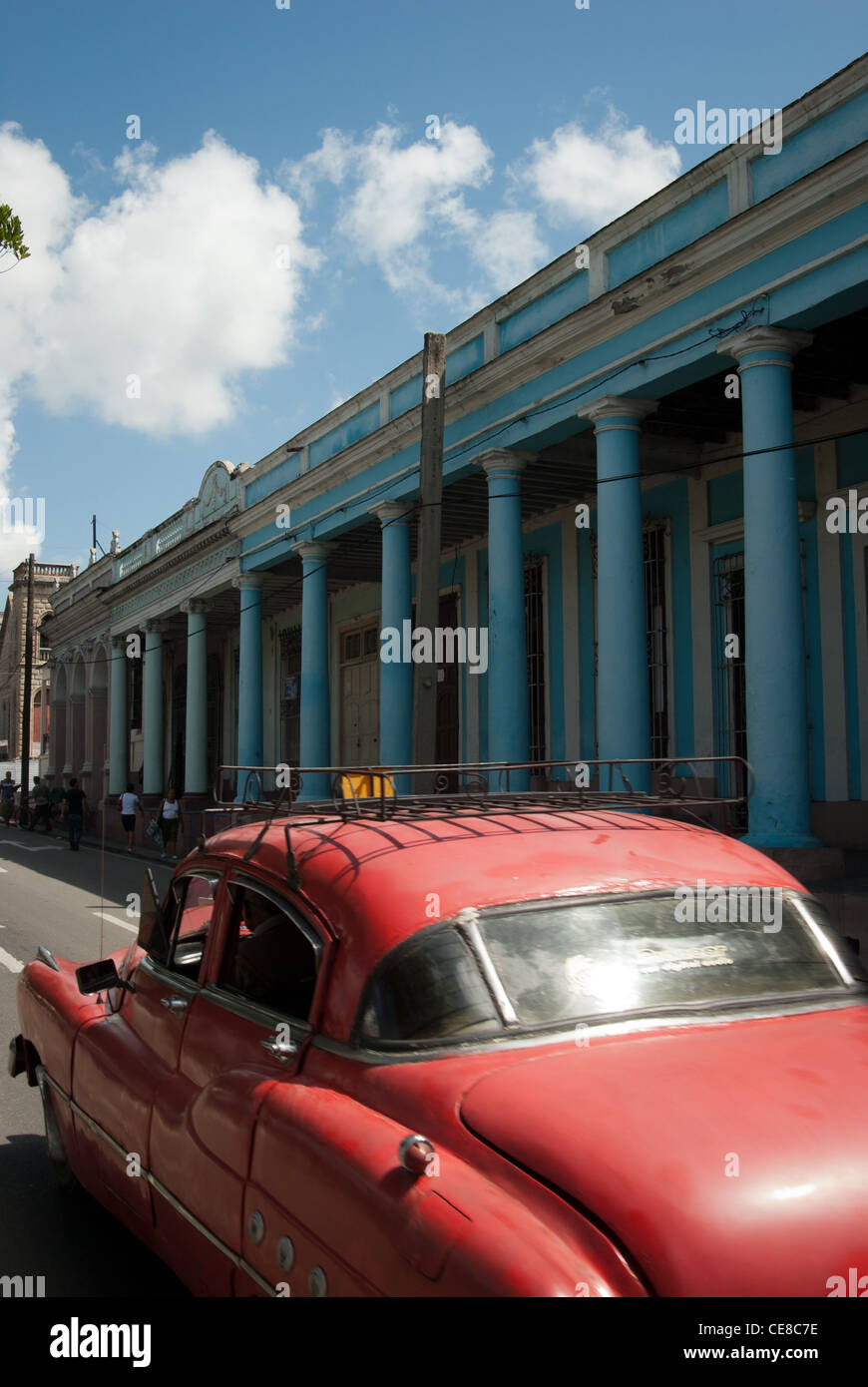 Old red car passing beautiful pillars in Cienfuegos Stock Photo