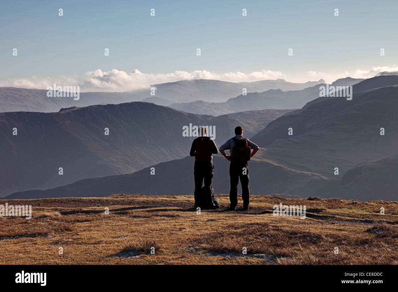 Two Hillwalkers Enjoying the View Towards the Southern Fells from the Mountain of Sail Lake District Cumbria UK Stock Photo