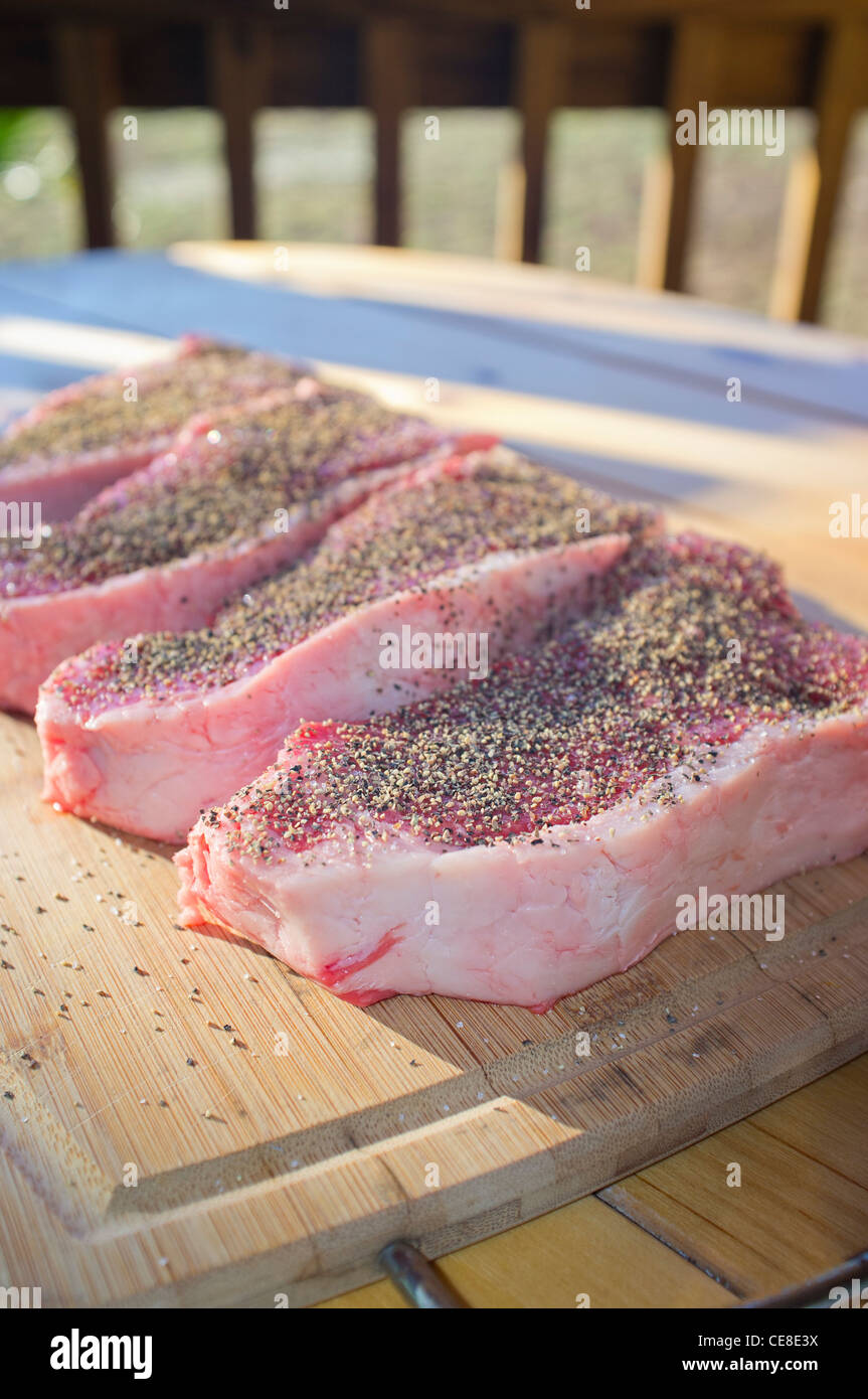 Beef strip loin steaks seasoned with salt and black pepper Stock Photo