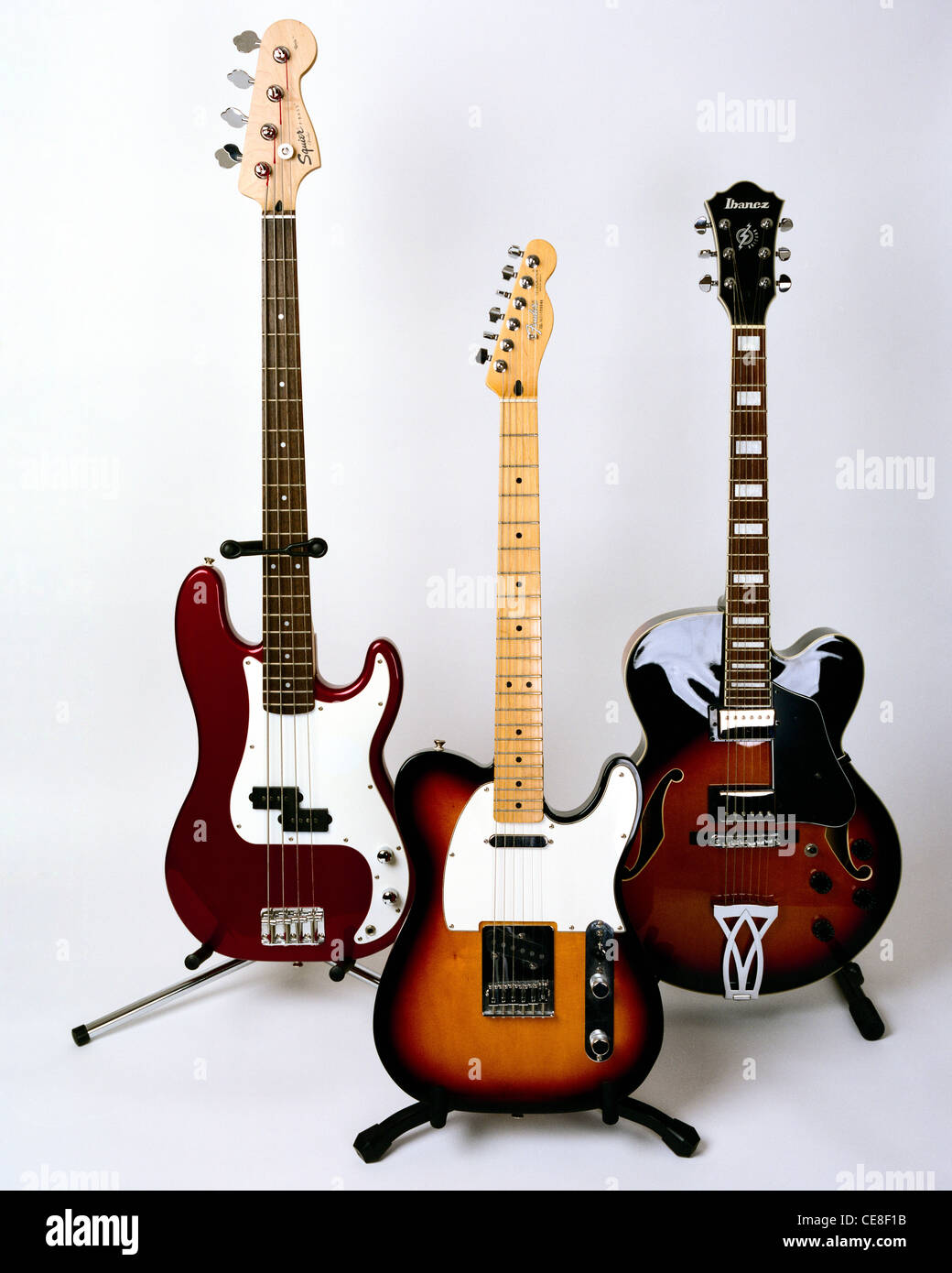 Three electric guitars on stands Stock Photo Alamy
