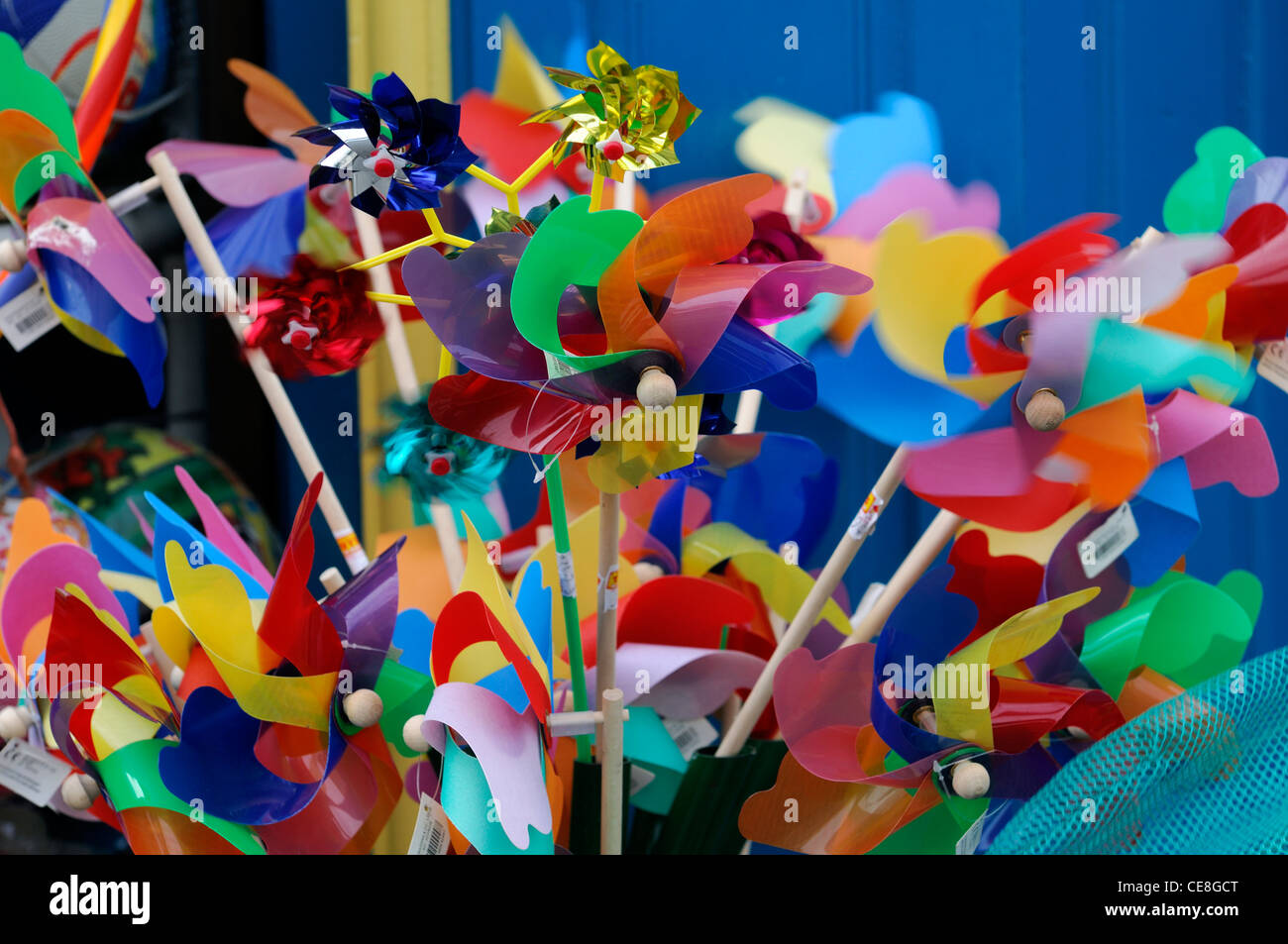 multicolor multicolored child child's children childrens windmill toy toys on sale outside shop