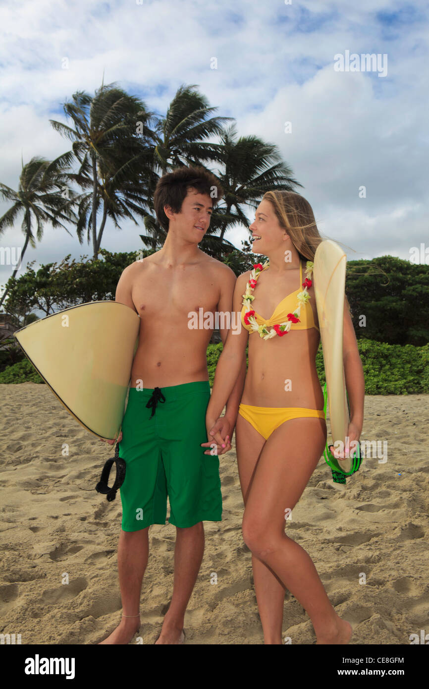 young couple at the beach with their surf boards Stock Photo