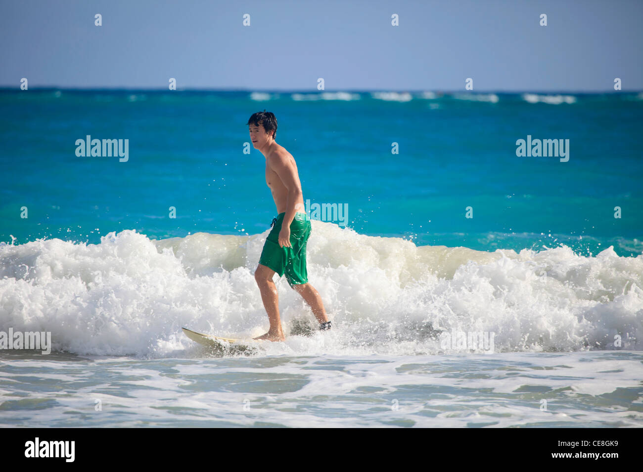 young asian american man surfing in hawaii Stock Photo