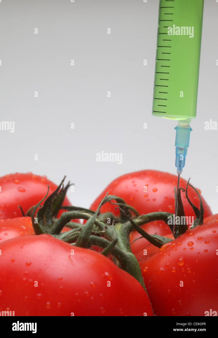 Injection into fresh red tomato Stock Photo