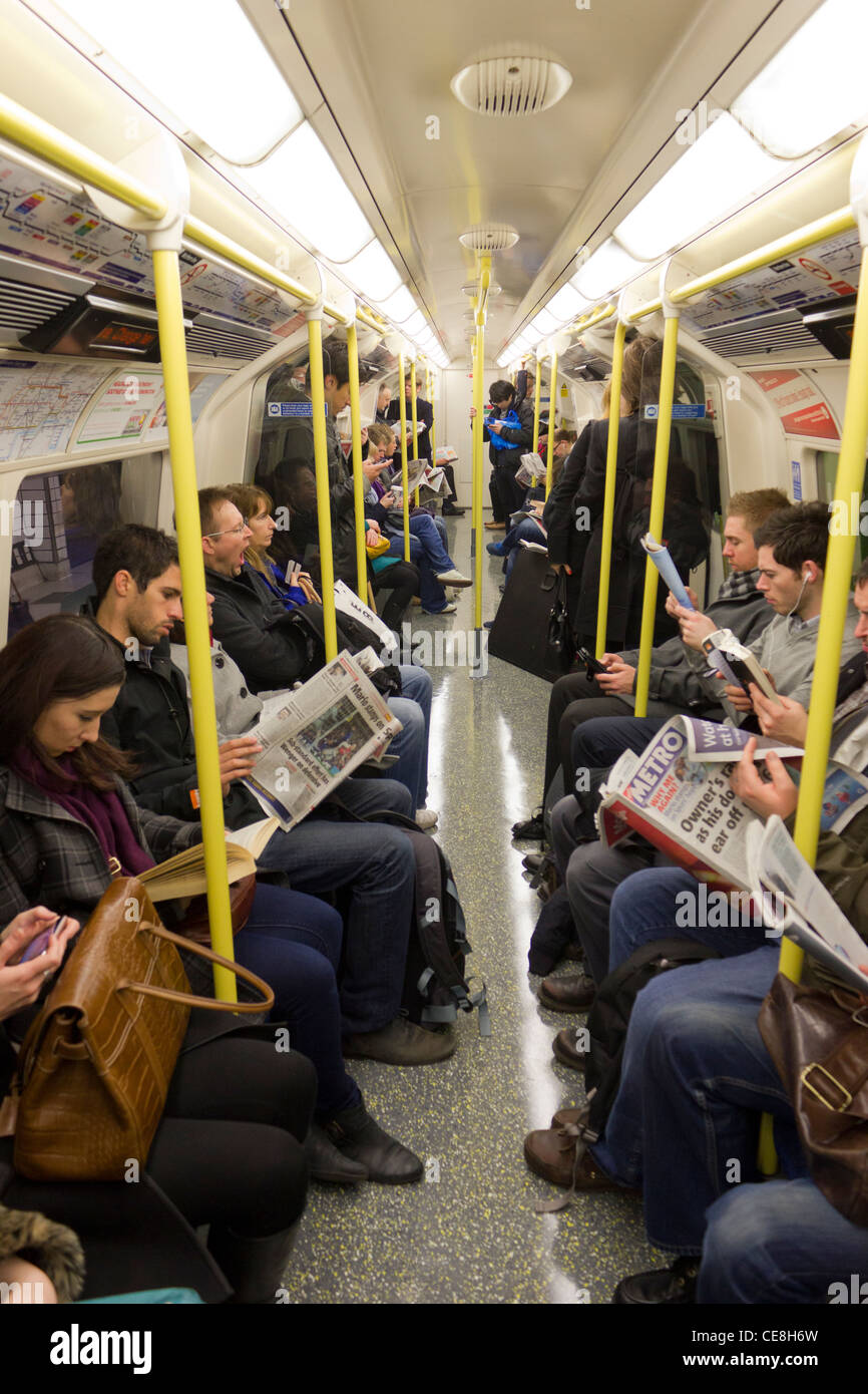 people reading newspapers on tube carriage, London Underground, London ...