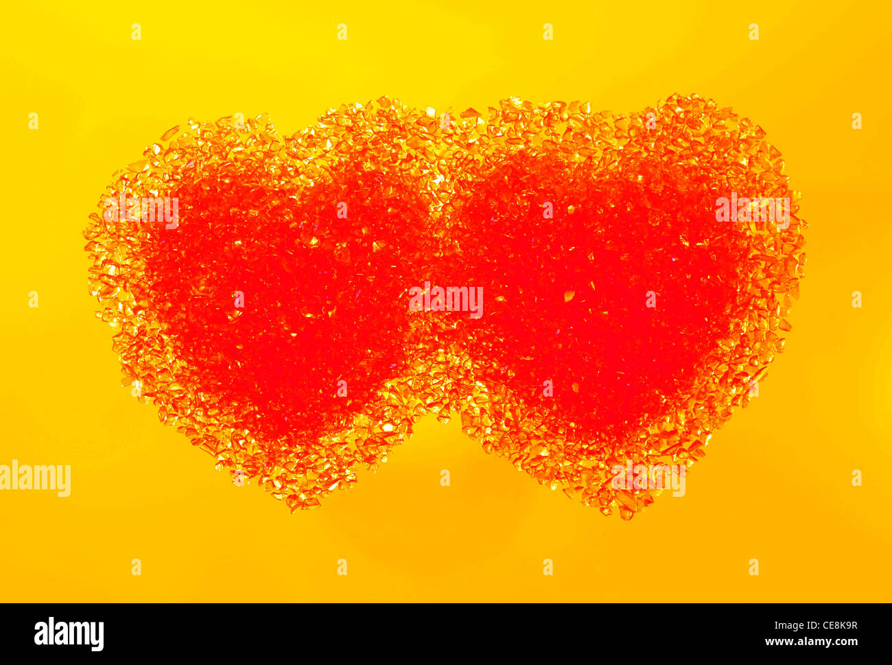 Two hot red hearts on a warm yellow background Stock Photo