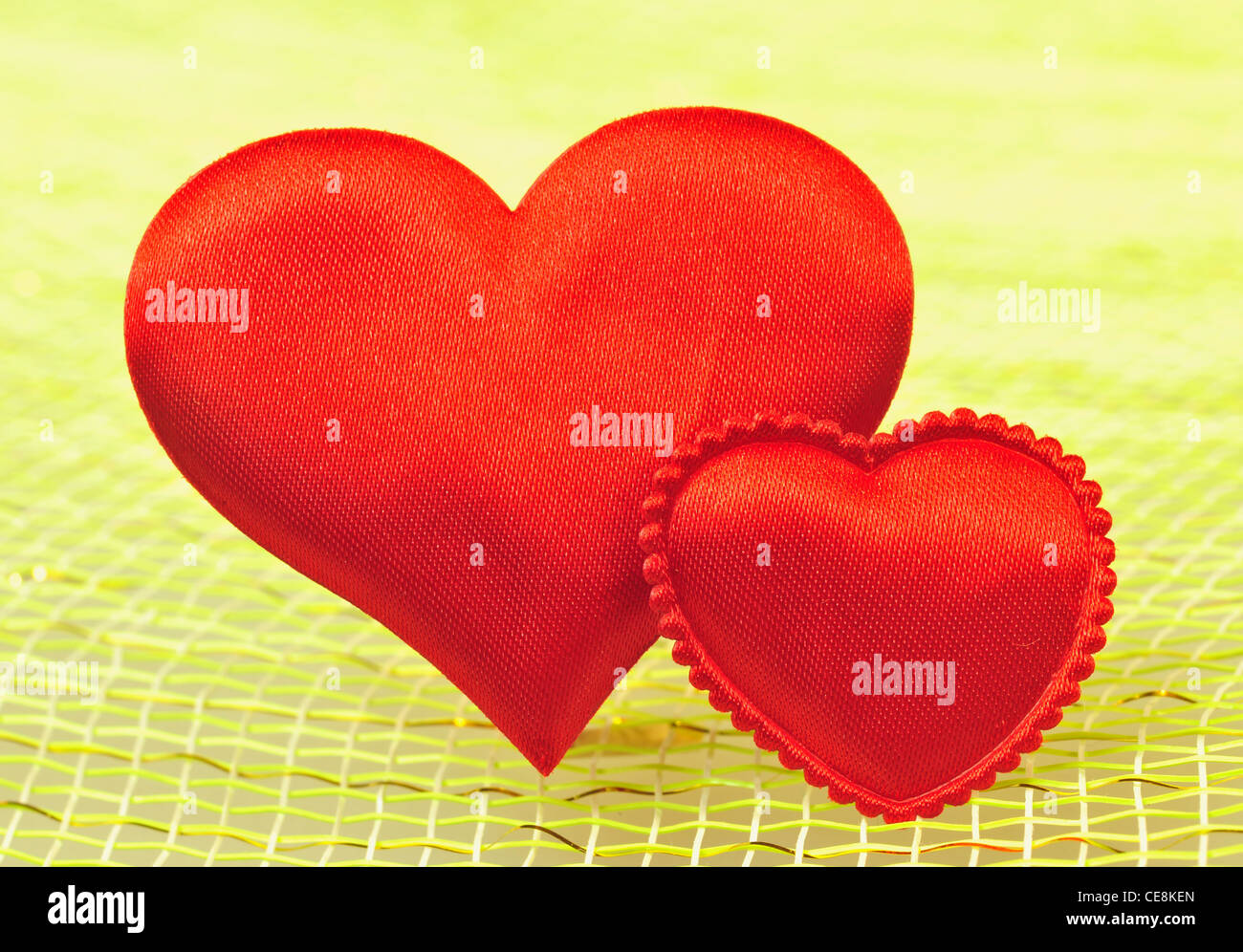 Two Silk red hearts on a light background. Stock Photo
