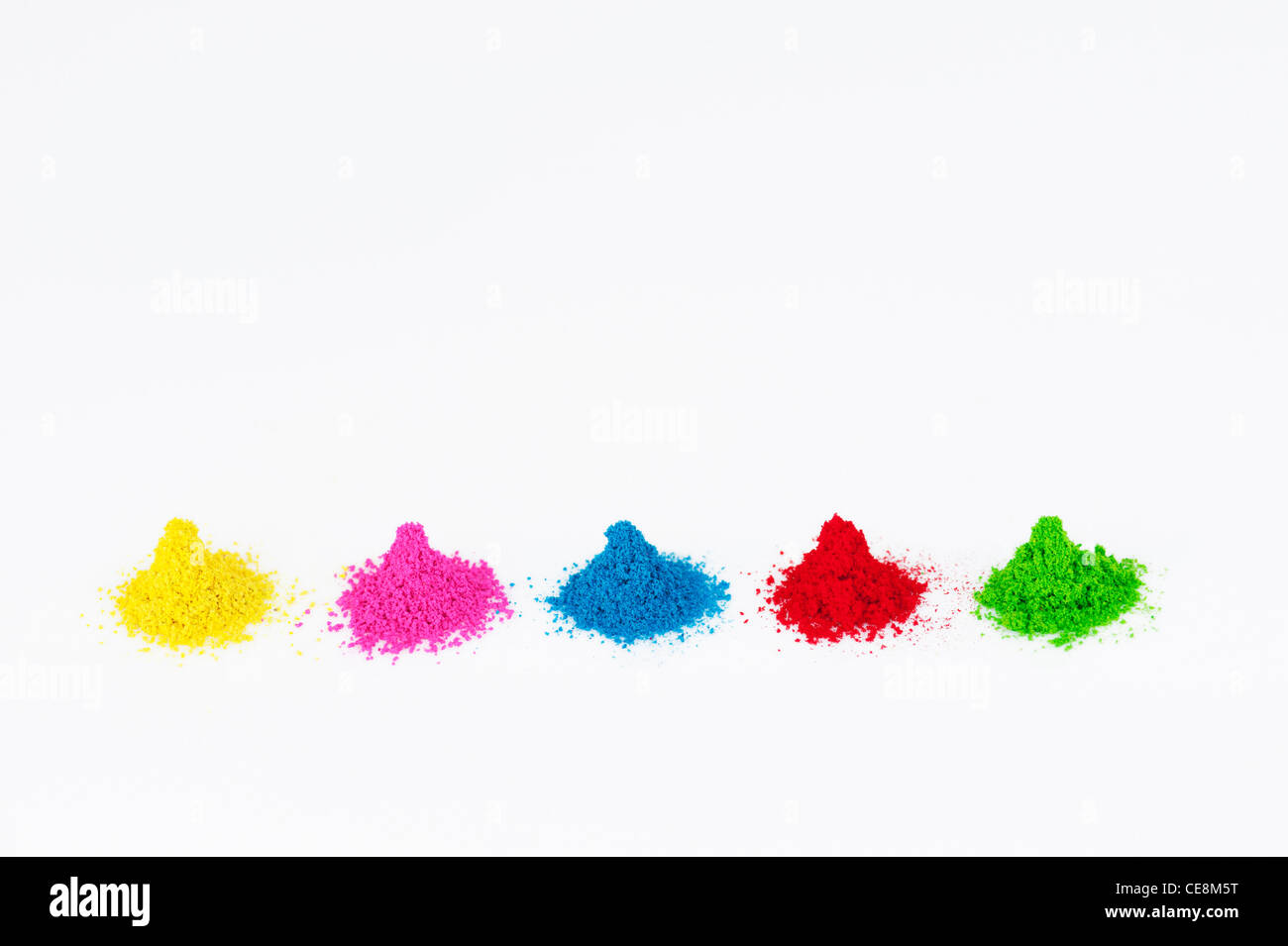 Piles of coloured Indian powder used for making rangoli designs. White Background Stock Photo