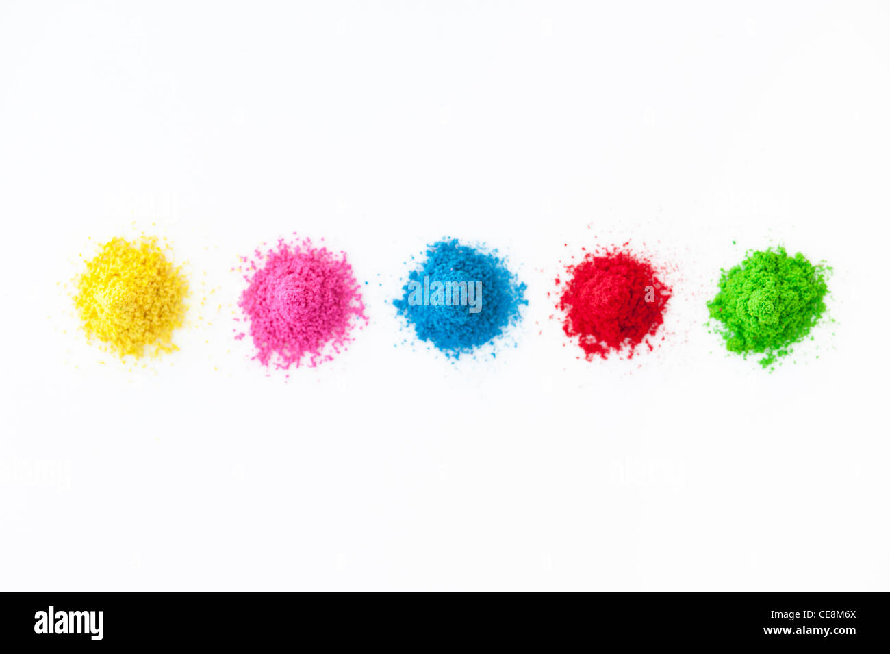 Piles of coloured Indian powder used for making rangoli designs. White Background Stock Photo