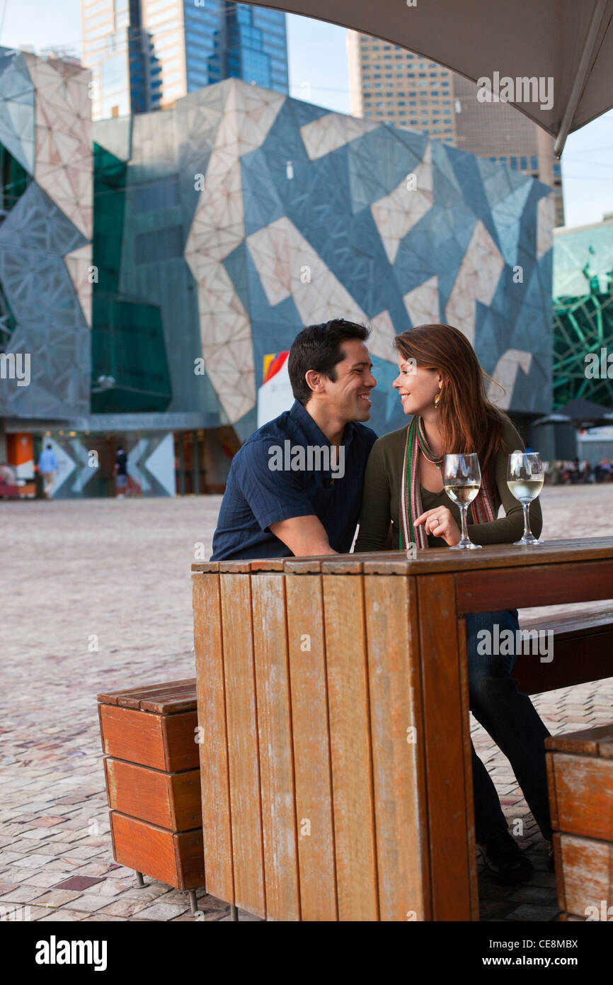 Young couple enjoying drink at an outdoor bar. Federation Square
