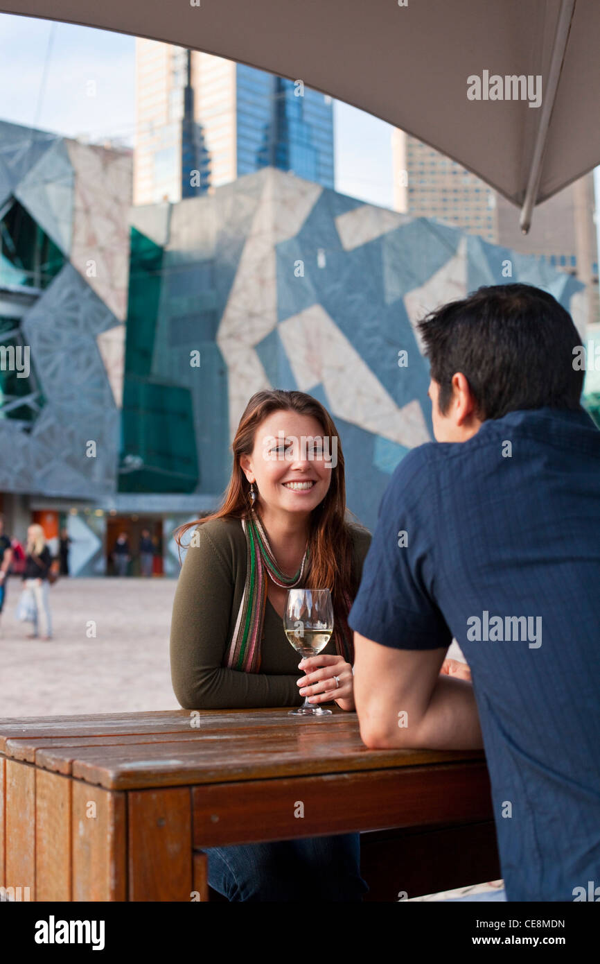 Young couple enjoying drink at an outdoor bar. Federation Square