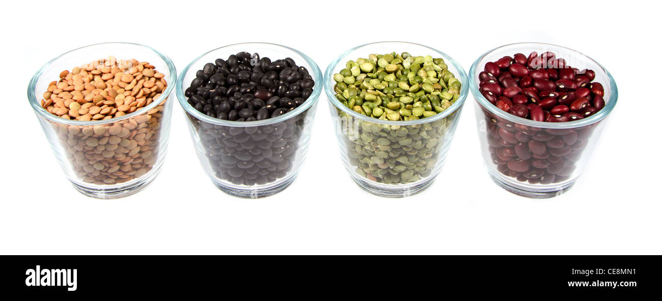 Four types of legums in glass containers, lentils, black beans, split peas, and red beans. Isolated on a white background Stock Photo