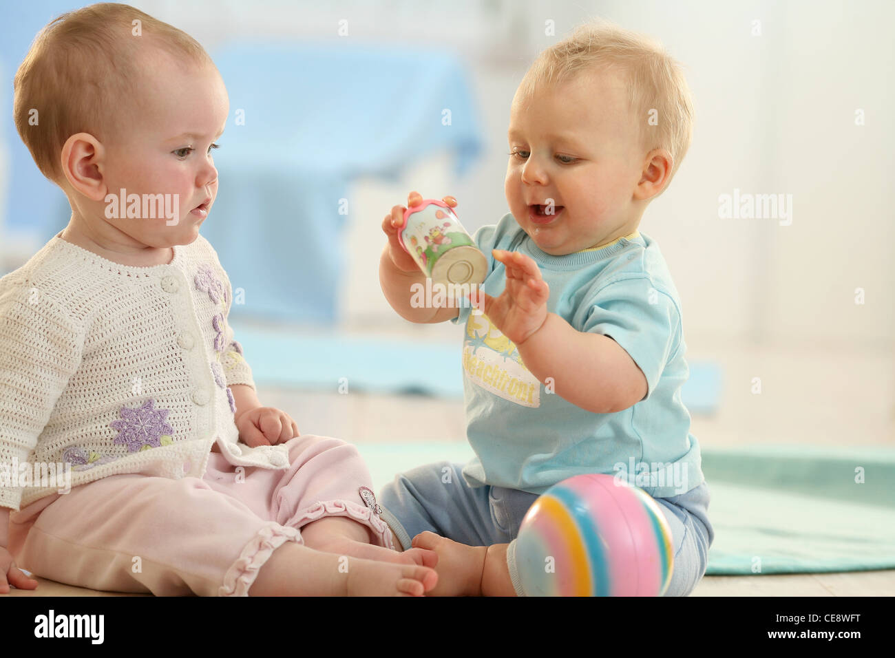 Two babies sitting on the floor Stock Photo Alamy