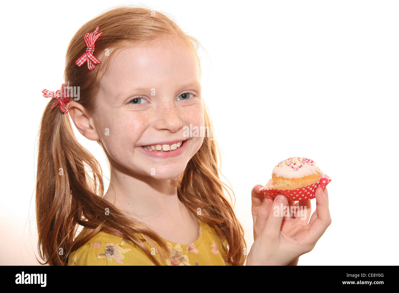 Happy little girl eating a pretty cup cake isolated Stock Photo Alamy