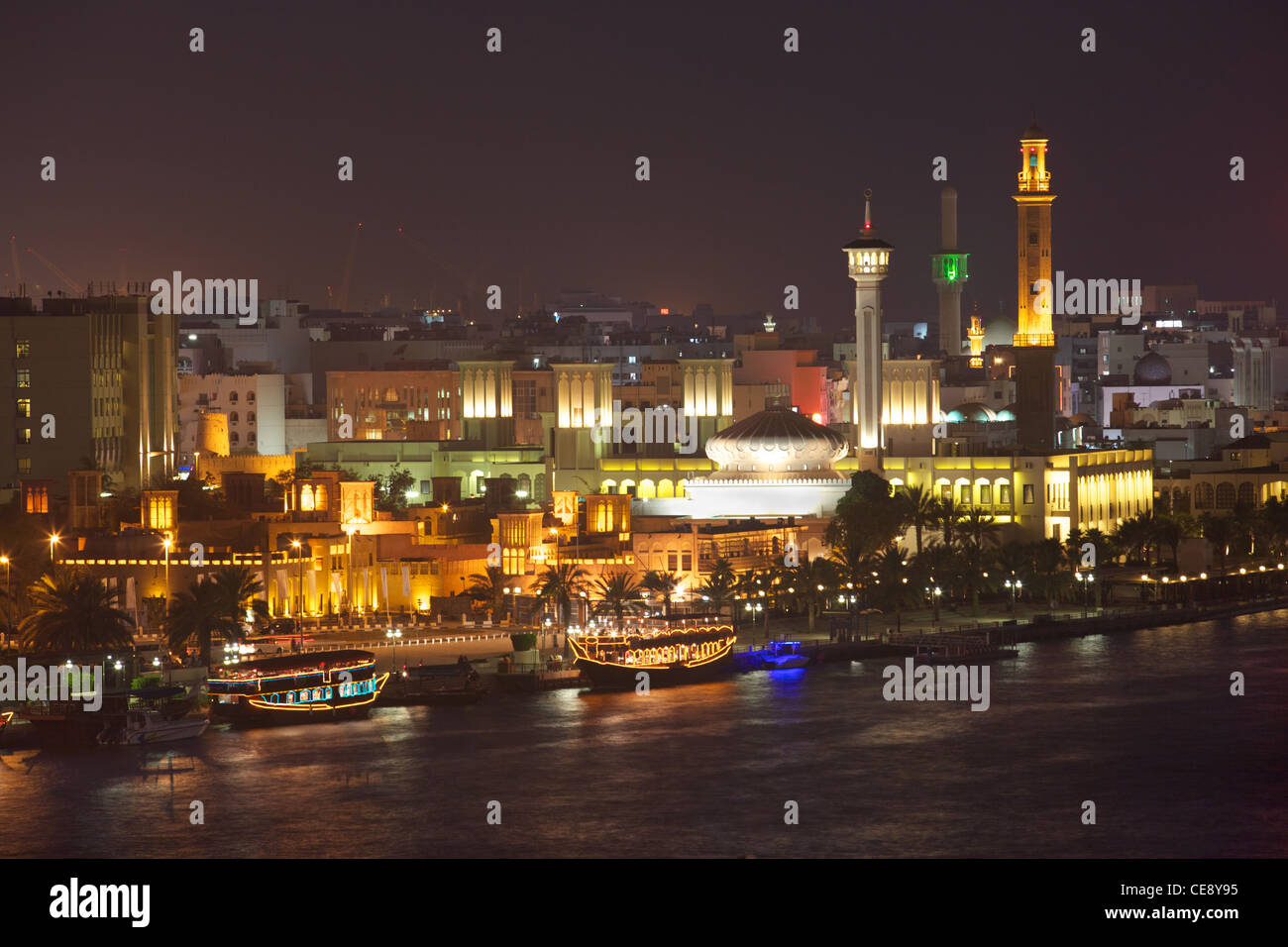 A night-time view of dhow restaurants on Dubai Creek, with the historic district of Bastakiya in the background. Stock Photo