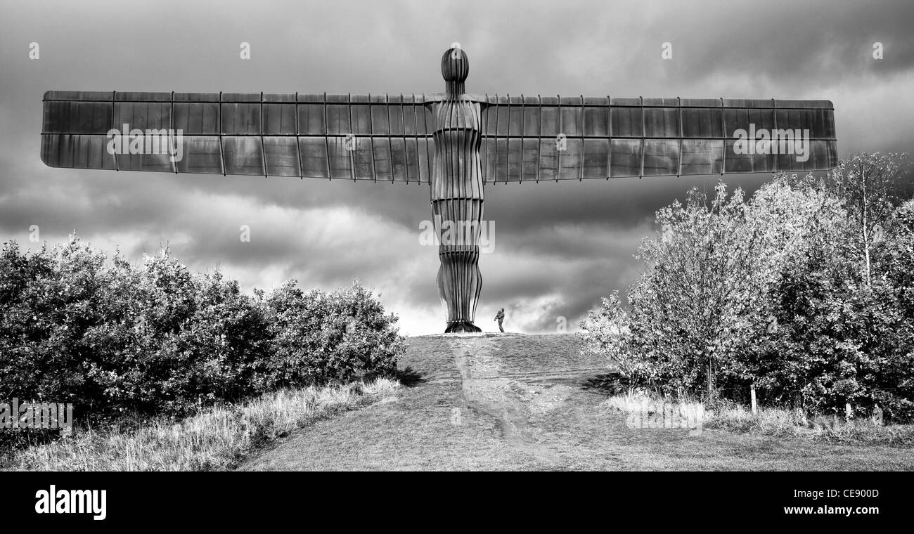 The Angel of The North in black and white with man and child looking up to it Stock Photo