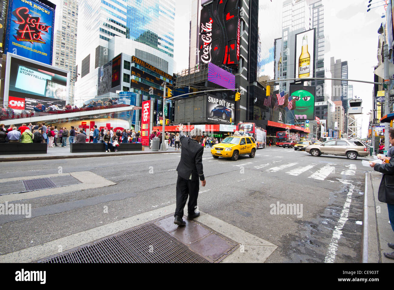 Doorman calls/hails taxi by waving hand in New York City. Stock Photo