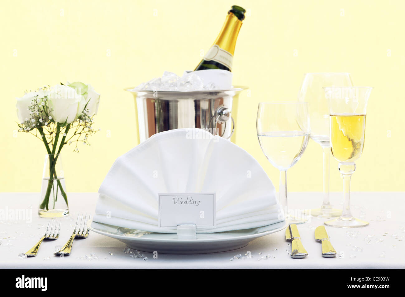 Photo of a wedding table place setting with place card and a bottle of chilled champagne in an ice bucket. Stock Photo