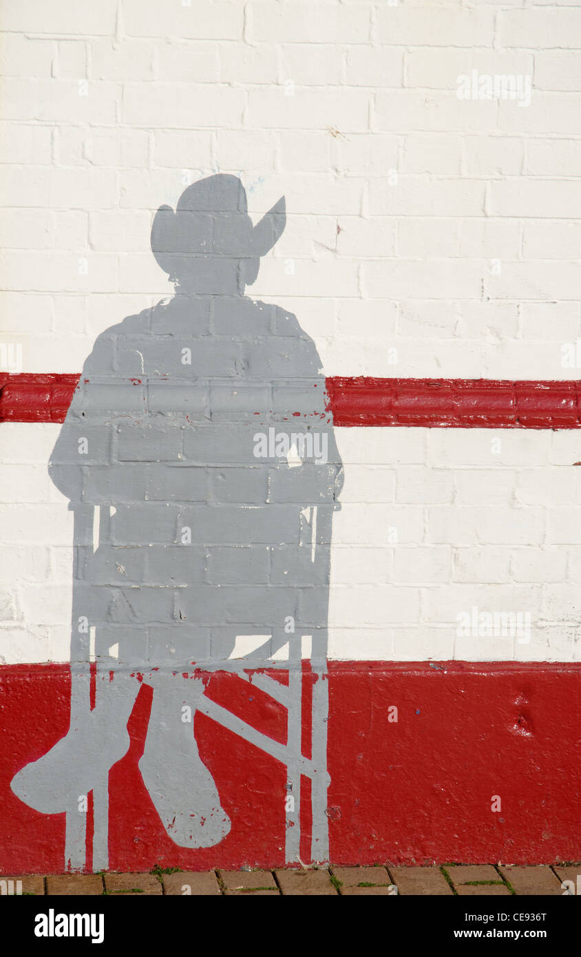 Outline of a male seated figure on a painted brick wall in Brighton Stock Photo