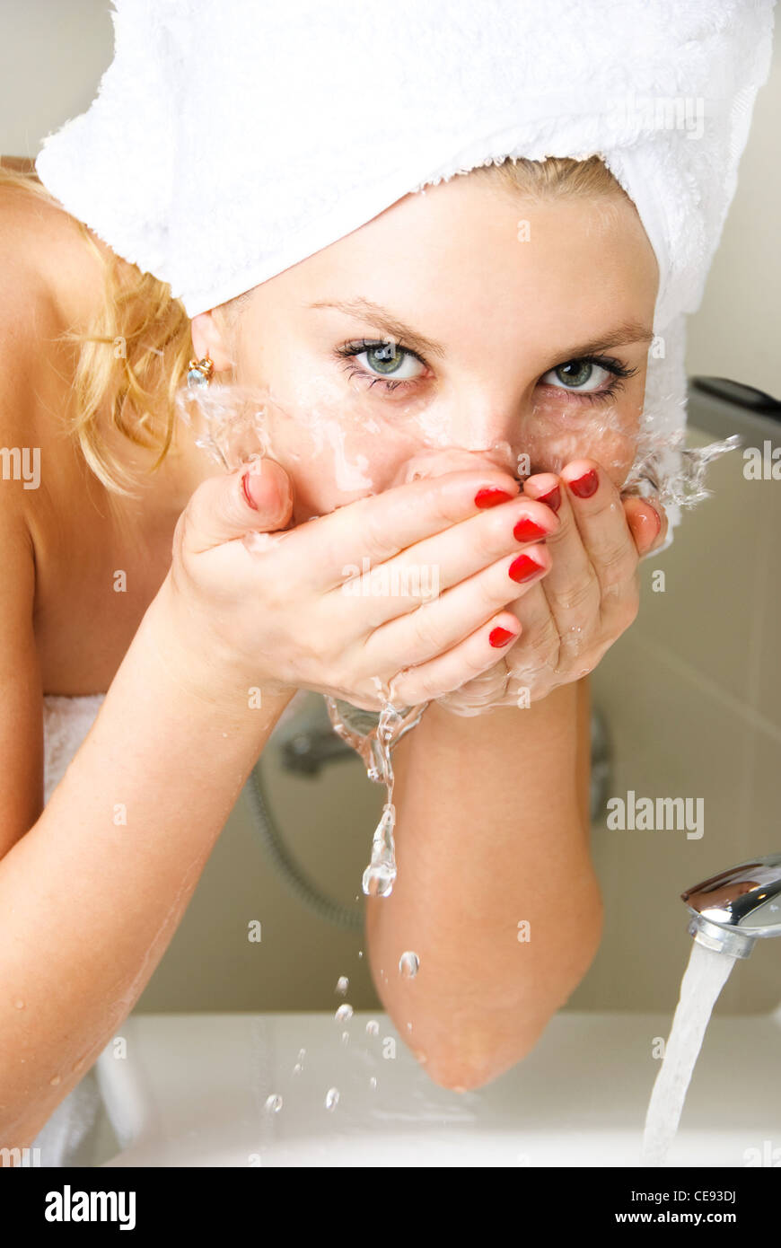 beautiful young woman washing her face in the bathroom Stock Photo Alamy