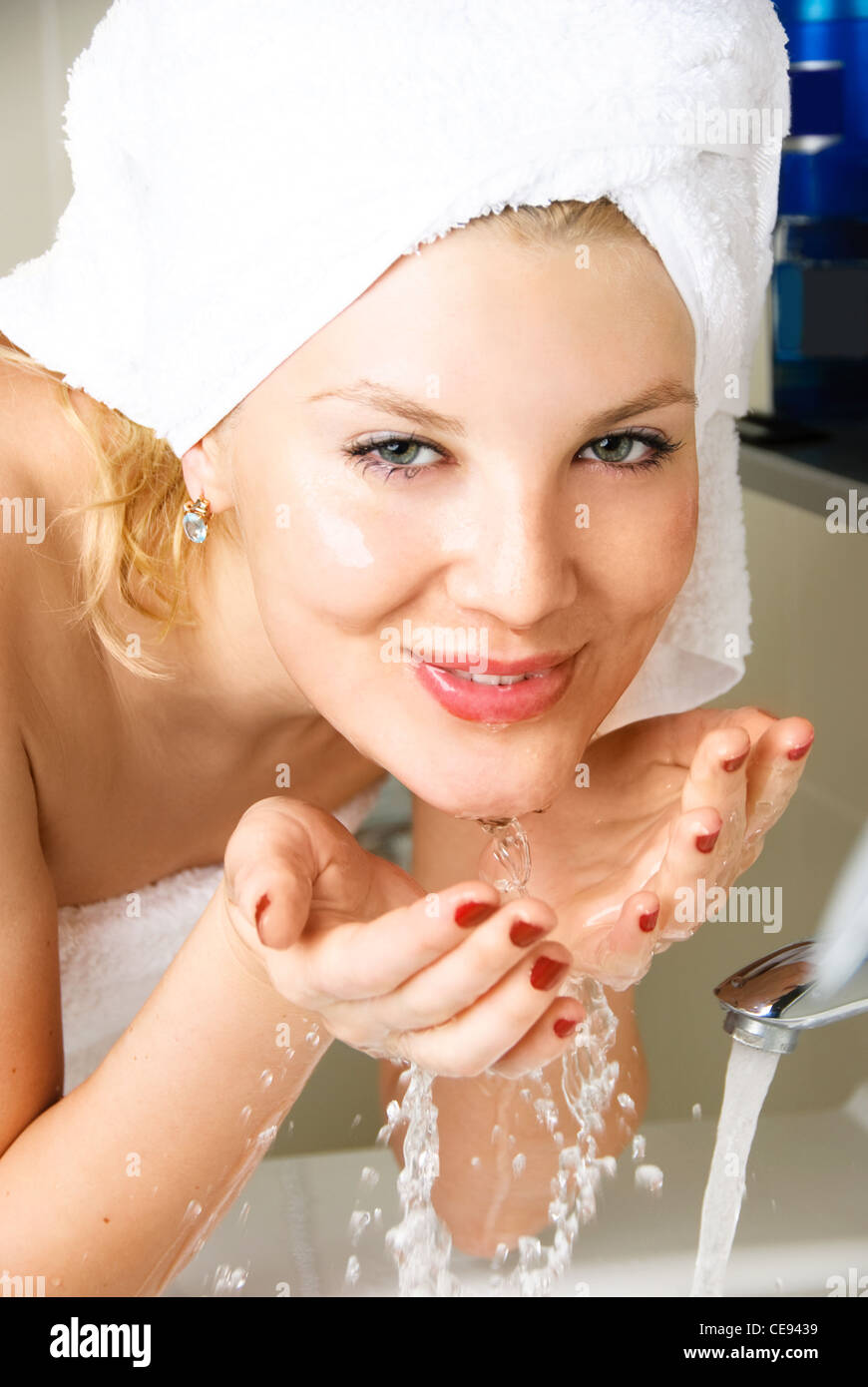 beautiful happy woman washing her face in the bathroom Stock Photo Alamy