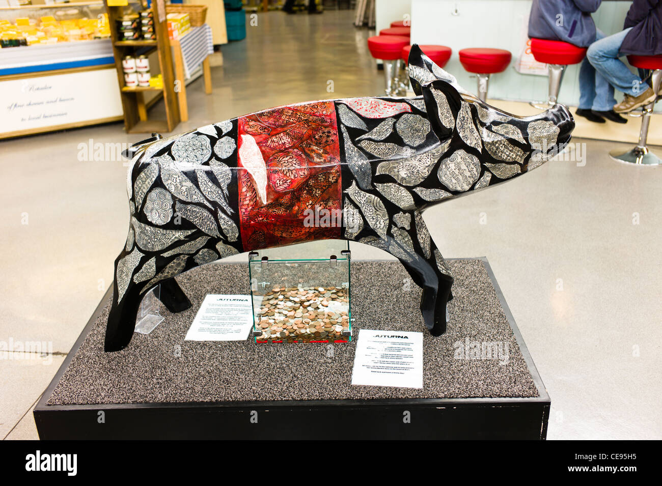 Decorated wooden pig as fund-raiser in small market Stock Photo