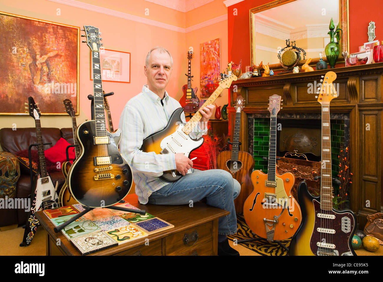 David Brewis of Rock Stars Guitars at home with some of his collection Stock Photo