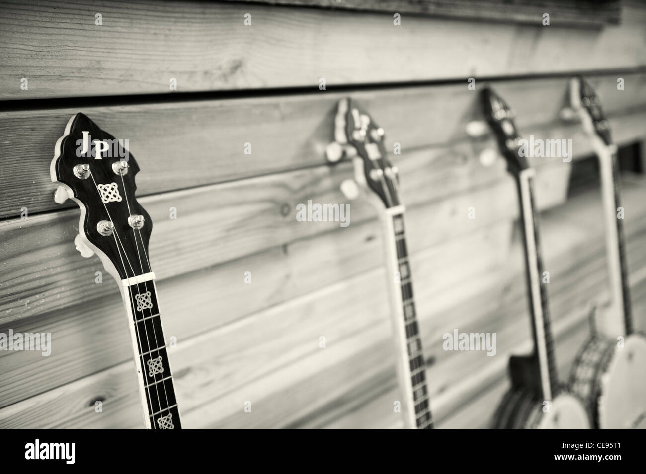 Four handmade Banjos resting against planks of wood Stock Photo Alamy
