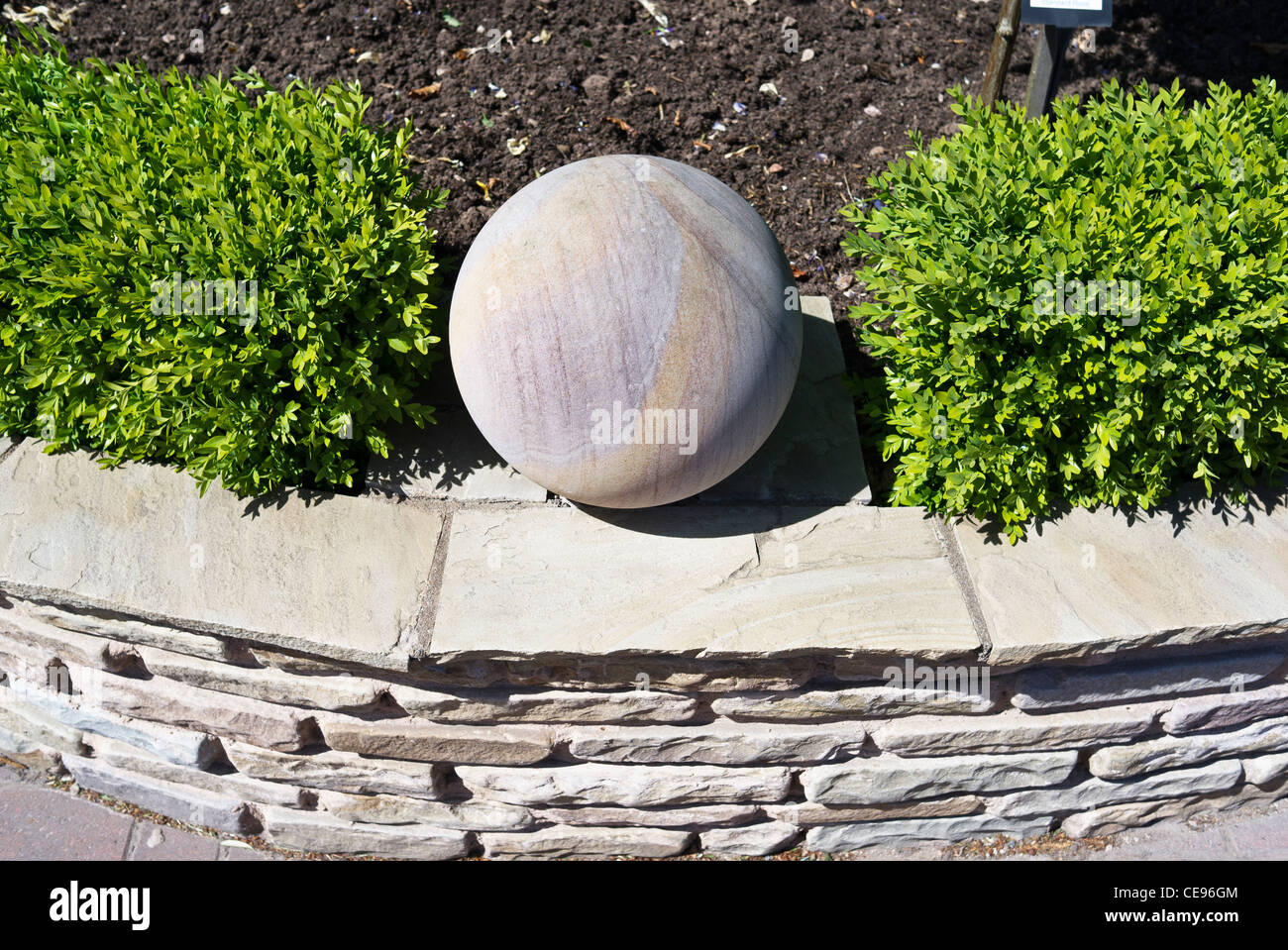 Ornamental sphere on small garden wall Stock Photo