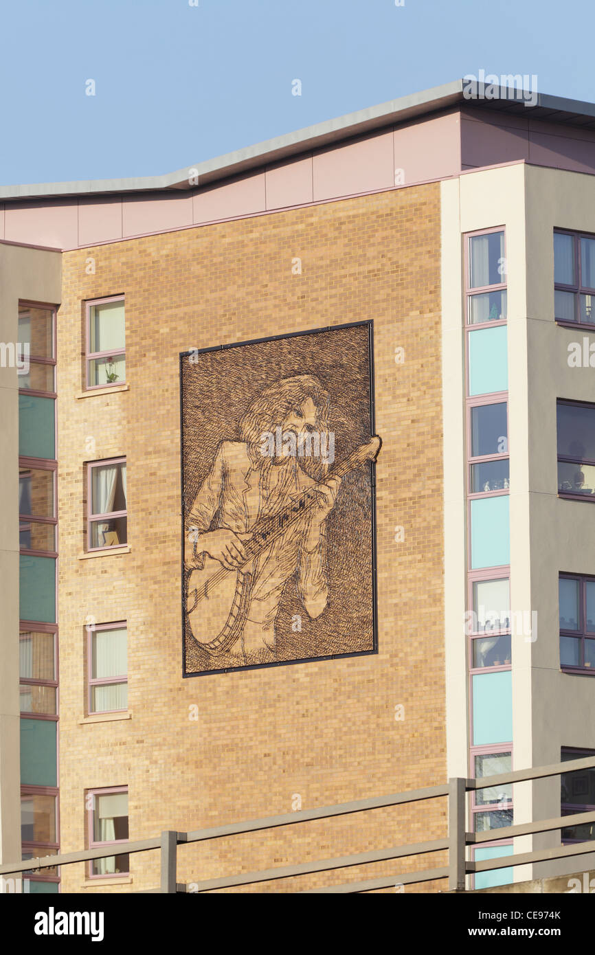 Billy Connolly playing banjo, steel mural of the comedian on a block of
