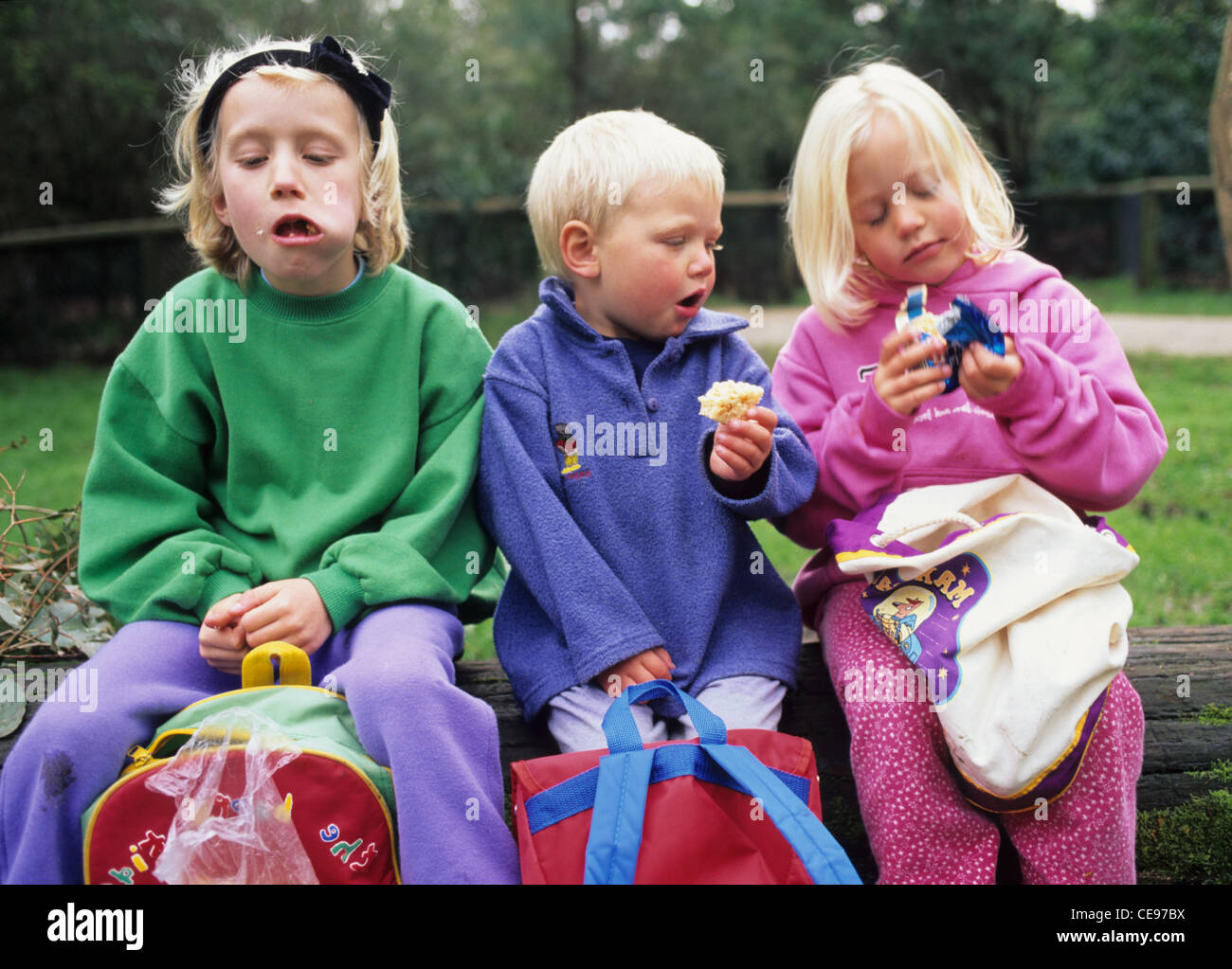 Children eating lunch on bench Stock Photo Alamy