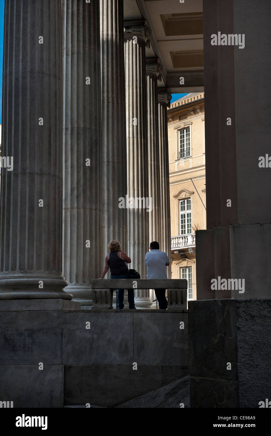 A couple sitting outside the Annunziata Basilica in Nunziata square. Genoa (Italian, Genova) Italy Stock Photo