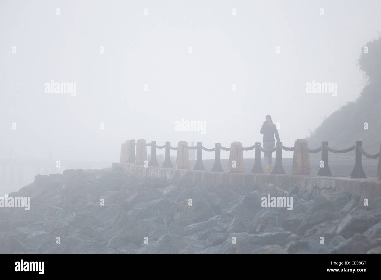 Woman walking in thick fog Stock Photo