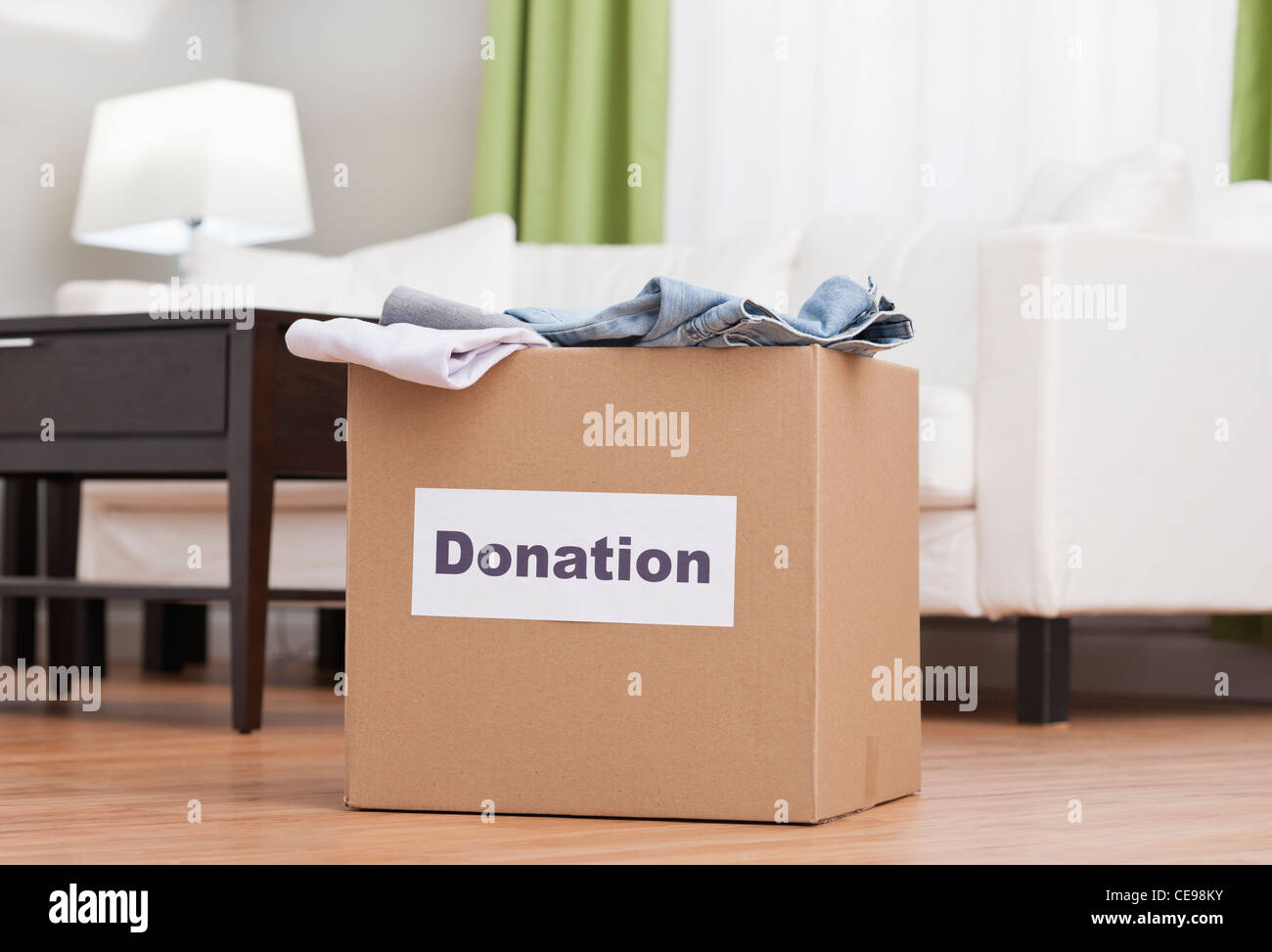USA, Illinois, Metamora, Cardboard box with clothes in living room Stock Photo