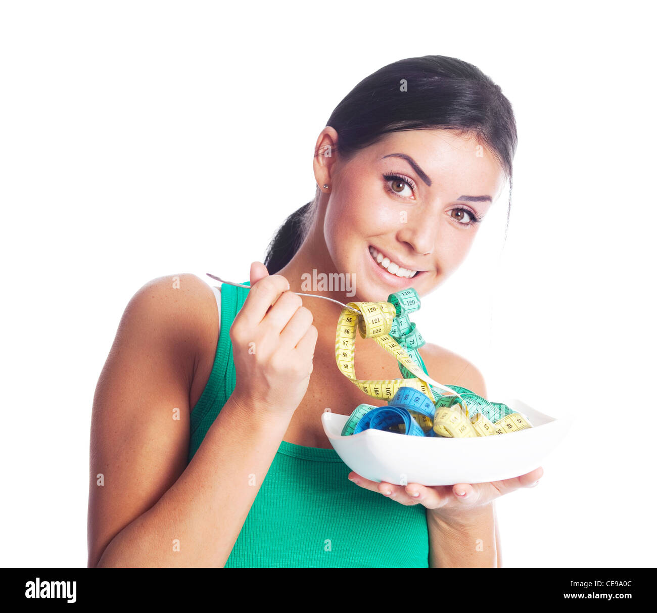 humorous portrait of a young woman keeping a diet and eating measuring