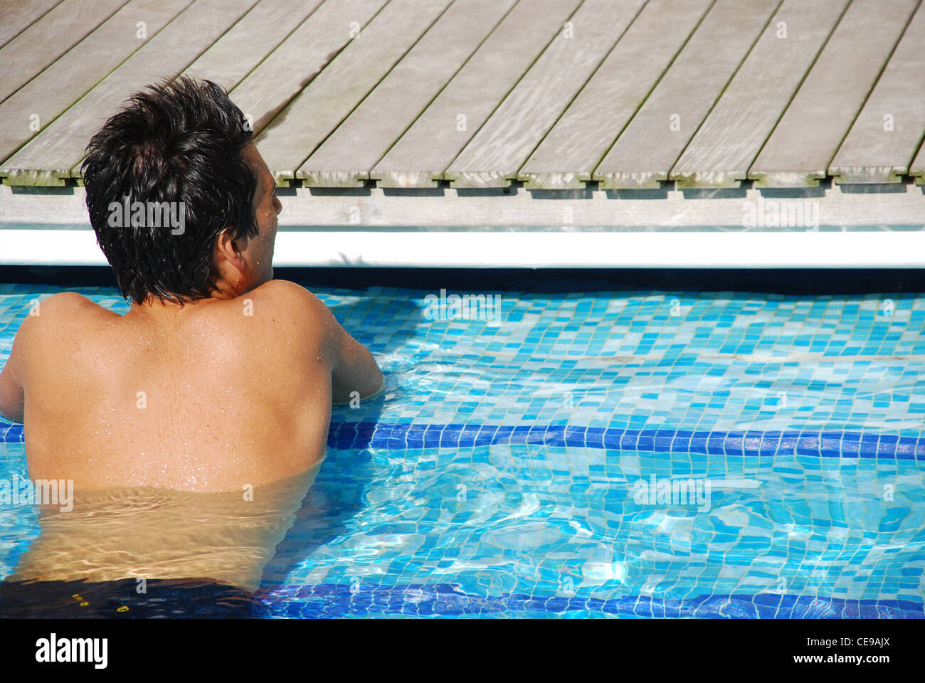 Man relaxing at swimming pool Stock Photo